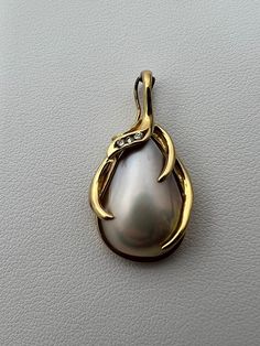 "A teardrop shaped Mother of Pearl encased by an elegant frame of 14K gold (stamped \"14K\") with three small diamonds embedded in it. This item weighs 4.6 grams with a length of 1.2 inches and the bail fits a 5mm chain, also works as a hinge to complement any pearl strand." Formal Teardrop Jewelry With Diamond Accents, Exquisite Teardrop Jewelry For Formal Occasions, Pear-shaped Jewelry With Diamond Accents For Formal Occasions, Formal Pear-shaped Jewelry With Diamond Accents, Formal Pear-shaped Pearl Drop Jewelry, Yellow Gold Teardrop Jewelry Stamped 14k, Exquisite Formal Jewelry With Teardrop Pendant, Exquisite Teardrop Pendant Jewelry For Formal Occasions, Gold Teardrop Jewelry For Formal Occasions