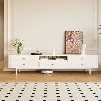 a living room with white furniture and black and white rug