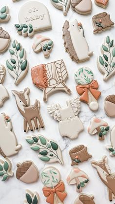 many decorated cookies sitting on top of a marble countertop with leaves and animals around them