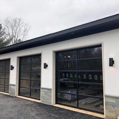 two garages with black and white doors in front of the parking lot at rockhard