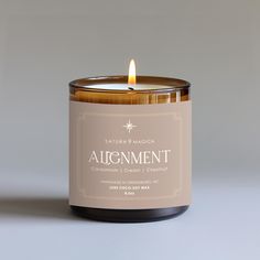 a candle that is sitting on top of a table in front of a gray background