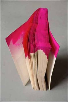 an open book with pink and red paint on it