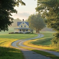 a house in the middle of a field with a dirt road leading to it and trees on either side