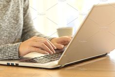 a woman typing on her laptop with a cup of coffee