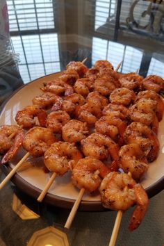 several skewers of shrimp on a plate with toothpicks stuck in them