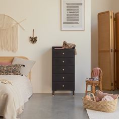 a bedroom with a dresser and bed in it