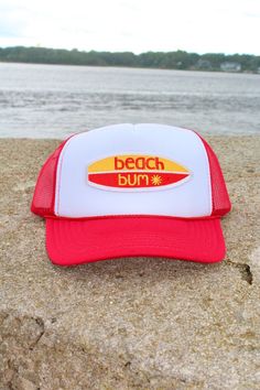 This adjustable OTTO trucker hat is so cute for summer time, it is adjustable and super comfy! It is a red color with a white face and it has a embroidered patch on it the patch is a surfboard that reads "beach bum"✨ Trendy 5-panel Trucker Hat For Beach, Beach-style Trucker Hat With 5-panel Design, White 5-panel Baseball Cap For Beach, Red 5-panel Summer Hat, Fun Curved Bill Beach Hat, Fun Curved Bill Snapback Hat For Beach, Summer Snapback Hat With Logo Patch And Flat Brim, Red Trucker Hat For Beach, Adjustable Red Baseball Cap For Beach