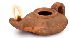 an old teapot with a lit candle in it's center on a white background