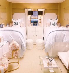 two beds in a room with white linens and pillows on top of each bed