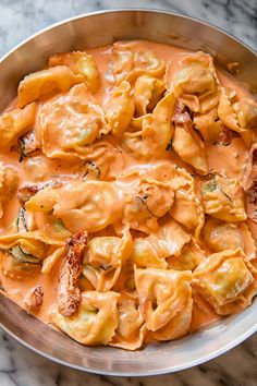 a pan filled with pasta and sauce on top of a table