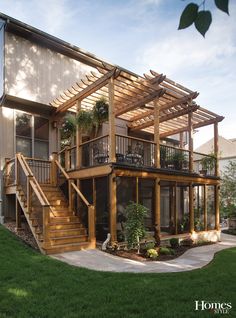 a large wooden house with stairs leading up to the second floor and covered patio area