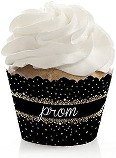 a black cupcake with white frosting and gold sprinkles on it