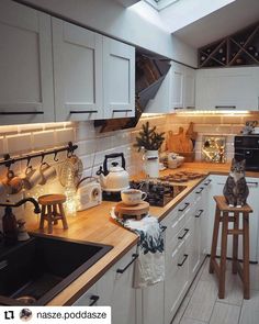 a kitchen filled with lots of counter space and white cupboards next to a stove top oven