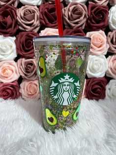 the starbucks cup is decorated with glitter, hearts and confetti as it sits in front of roses