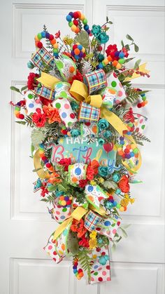 a colorful wreath is hanging on the front door with polka dots and ribbons around it