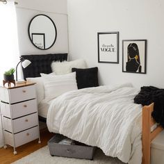 a bedroom with white bedding, black and white decor and pictures on the wall