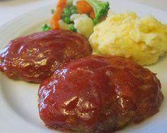 two meatballs covered in ketchup on a plate with mashed potatoes and broccoli