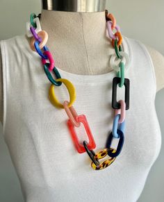 a multicolored necklace on a mannequin with a white t - shirt