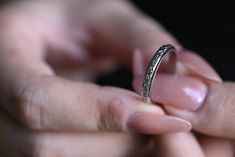 a close up of a person holding a ring in their hands with the other hand