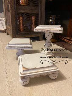 an old fashioned white table with two small trays sitting on it's sides