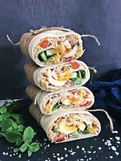 three burritos stacked on top of each other with vegetables and meat in them