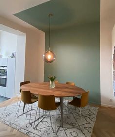 a dining room table with chairs and a rug on the floor in front of it