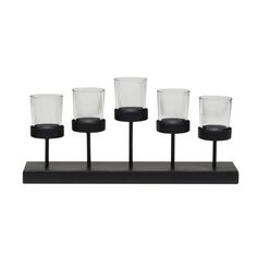 four black and clear glass cups on a wooden stand with five glasses in the middle