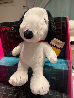 a white stuffed dog sitting on top of a bath tub