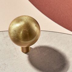 a golden door knob sitting on top of a white table next to a pink wall