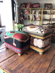 two ottomans sitting on top of a wooden table