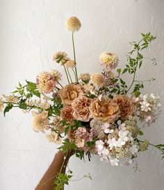 a person holding a bouquet of flowers in their hand