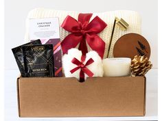 a gift box filled with chocolates, cookies and other holiday treats sits on a table