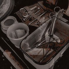 an assortment of tools are sitting on top of a metal tray in black and white