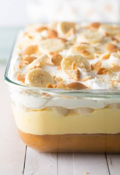 a banana pudding in a glass dish on a wooden table