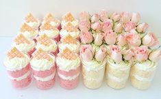 there are many pink and white cupcakes in the vases on the table