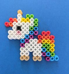 an animal made out of plastic beads on a blue surface with white, yellow, green, and red circles