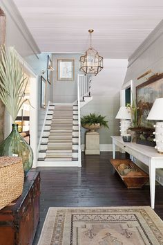 the inside of a house with stairs and rugs