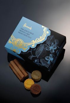 an assortment of cookies and crackers on a black table with a blue box in the background