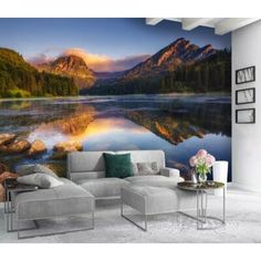 a living room with a couch and large wall mural on the wall, it has a mountain lake in the background