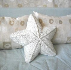 a white starfish pillow sitting on top of a bed