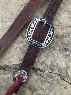 "Hand made 1.5\" wide headstall with buckle. These headstalls are made in our shop and are made to order. Buckles may vary as inventory changes and new styles are released. They are made from Heavy 14/16 ounce Herman Oak leather. Embossed with the Western Floral, Basketweave, Plain, and soon barbwire. Jermiah Watt Hardware is used and is top quality stainless steel hardware. These headstall get compliments wherever you go and a great using piece of tack." Adjustable Brown Traditional Belt Buckles, Traditional Adjustable Brown Belt Buckles, Rustic Hand Tooled Adjustable Belts, Traditional Adjustable Belt Buckle With Antique Detail, Western Belt Buckles For Festivals, Adjustable Western Belt Buckles For Festivals, Western Style Belt Buckles For Festivals, Rustic Adjustable Brown Belt Buckles, Adjustable Western Belts For Festivals