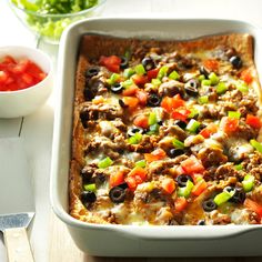 a casserole dish filled with meat, cheese and veggie toppings