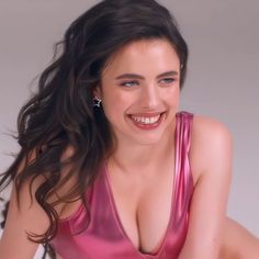 a woman in a shiny pink dress smiling