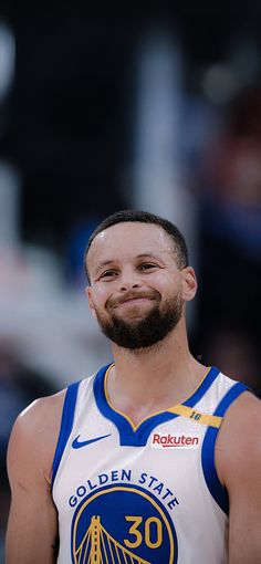 a basketball player with a beard smiles at the camera