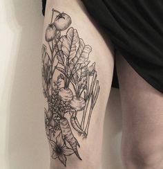 a woman's thigh with some flowers and plants on the side by her legs