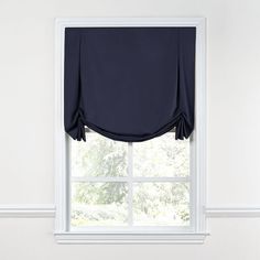 a window with a dark blue curtain hanging from it's side and a white wall in the background