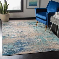 a living room with blue chairs and a rug