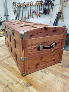 a large wooden trunk sitting on top of a hard wood floor in a shop or workshop