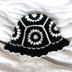 a black and white crocheted hat laying on top of a bed