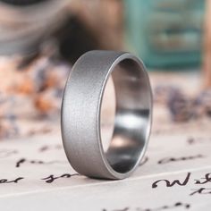 a silver ring sitting on top of a piece of paper with writing in the background